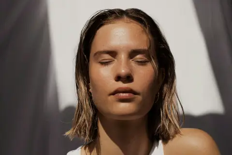 Woman resting with her eyes closed in warm sunlight