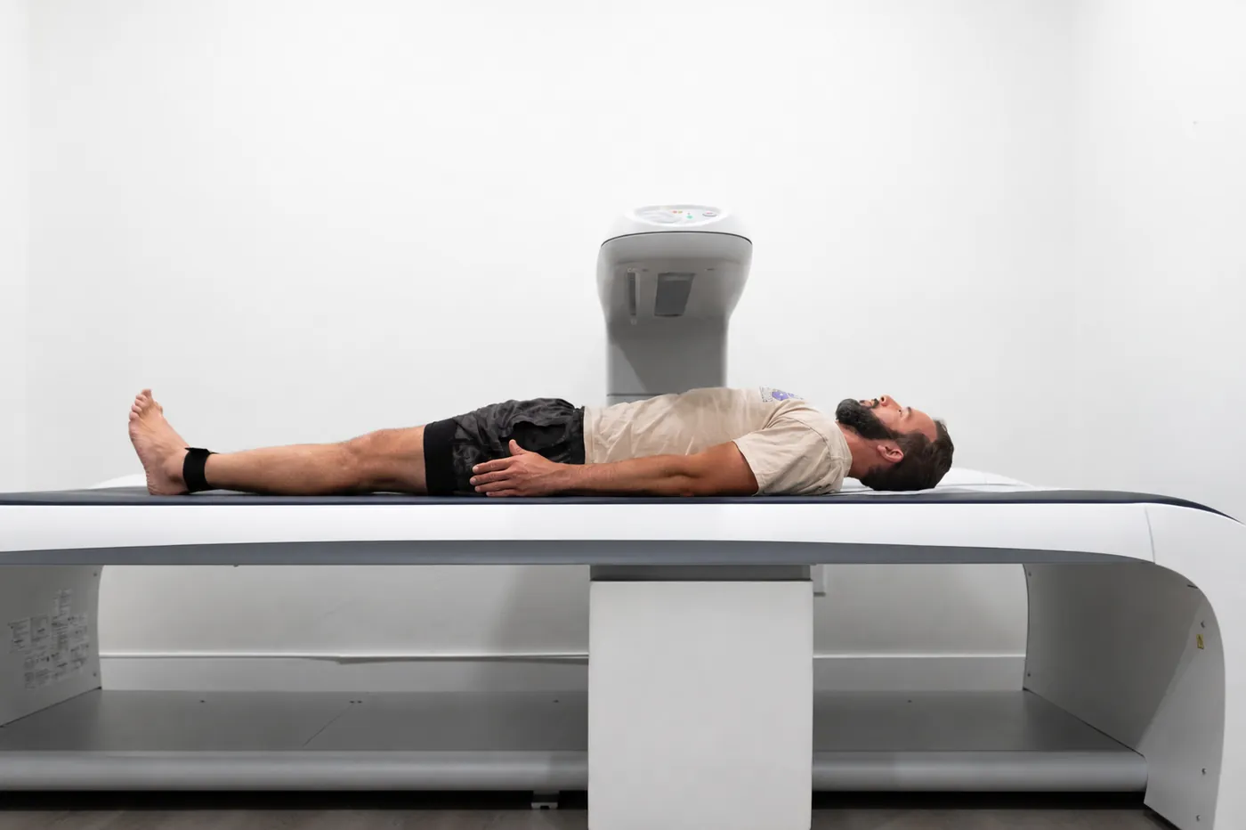 A person lying on a GE DEXA scanner during a body composition scan