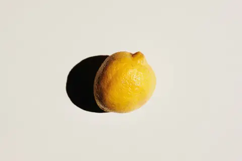 A single lemon on a plain white surface