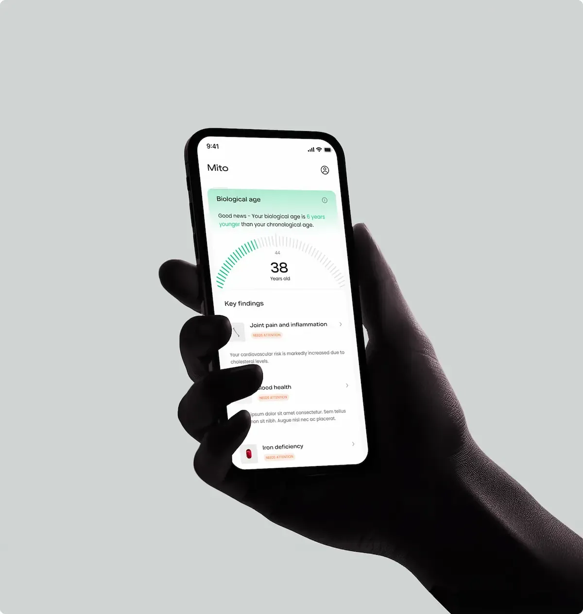Hand holding phone with Mito Health app showing biological age and key findings
