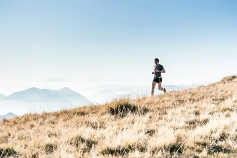 Man running along a mountain trail