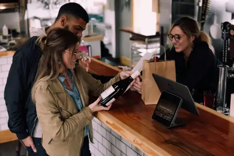 Friends choosing a bottle of wine in a warmly lit shop