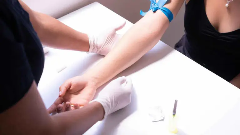 A phlebotomist drawing a blood sample from a person arm