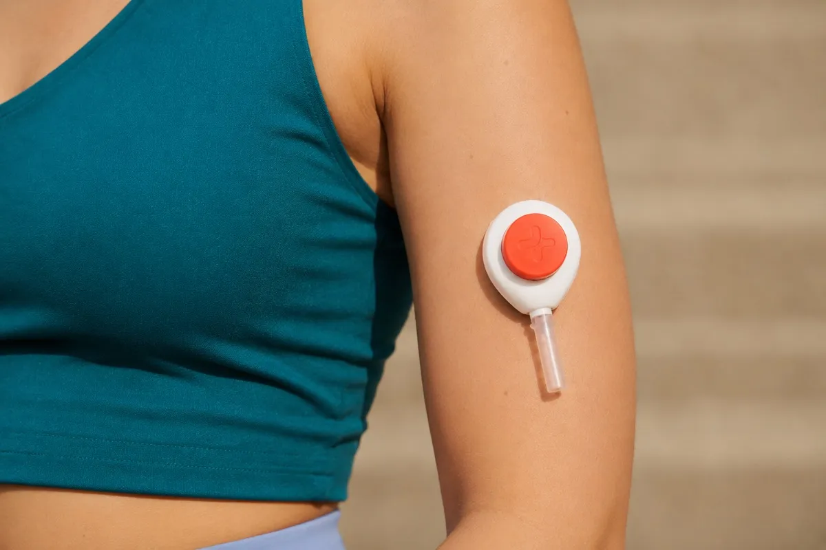 An at-home blood test kit with a Tasso+ collector on a kitchen table