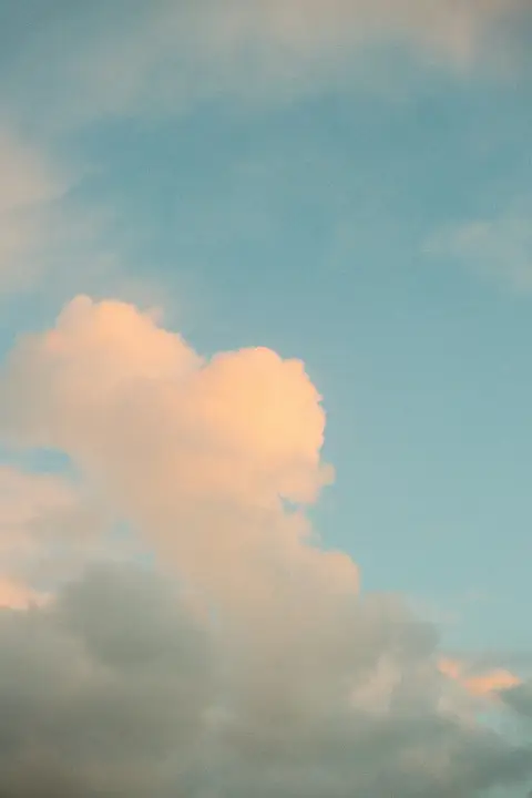 Warm clouds in a pale blue sky